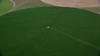 AX130_092 - 5.5K aerial stock footage of approaching circular crop field, tilt to irrigation system, Elberta, Utah