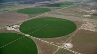 AX130_093 - 5.5K aerial stock footage of approaching circular crop fields and tilt to one of them, Elberta, Utah