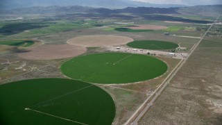 AX130_096 - 5.5K aerial stock footage of flying toward circular crop fields, access road, Elberta, Utah