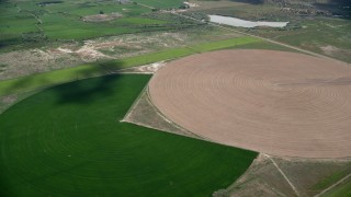 AX130_100 - 5.5K aerial stock footage of passing by Pac-man shaped and circular crop fields, Elberta, Utah