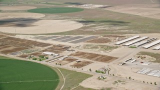 AX130_101 - 5.5K aerial stock footage of flying by circular crop fields, greenhouses, ponds, Elberta, Utah