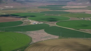 AX130_103 - 5.5K aerial stock footage of a view of large field of circular crop fields, Elberta, Utah