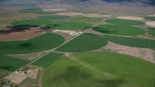 AX130_105 - 5.5K aerial stock footage of flying by large field of circular crop fields, Elberta, Utah