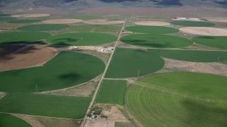 AX130_106 - 5.5K aerial stock footage of passing large circular crop fields, Elberta, Utah