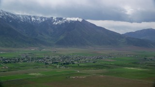AX130_108 - 5.5K aerial stock footage of flying by small town near the Wasatch Range, Mona, Utah
