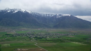 AX130_110 - 5.5K aerial stock footage of a view of a small rural town by base of Wasatch Range, Mona, Utah
