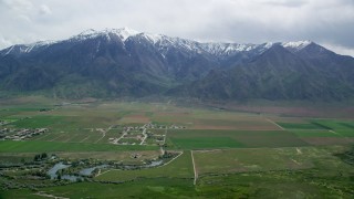 AX130_113 - 5.5K aerial stock footage of flying by Burraston Ponds, small rural town, Wasatch Range, Mona, Utah