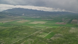 AX130_115E - 5.5K aerial stock footage of approaching small rural town, farmland, Nephi Municipal Airport, Nephi, Utah