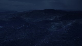 AX130_132_DFN - Aerial stock footage of 4K day for night color corrected aerial footage of flying by shadowy mountains, trees, Wasatch Range, Utah