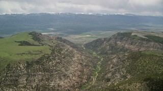 AX130_133E - 5.5K aerial stock footage of approaching a valley over mountain peaks, Wasatch Range, Utah