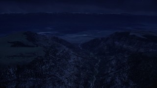 AX130_133_DFN - Aerial stock footage of 4K day for night color corrected aerial footage of approaching a valley beyond mountain peaks, Wasatch Range, Utah