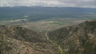 AX130_135 - 5.5K aerial stock footage approaching a valley from between two mountain peaks, Wasatch Range, Utah