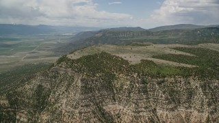 AX130_136E - 5.5K aerial stock footage of flying by mountain peaks, slopes with trees, Wasatch Range, Utah