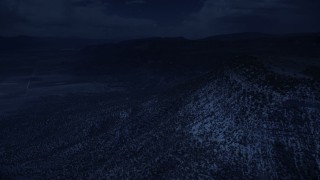 AX130_137_DFN - Aerial stock footage of 4K day for night color corrected aerial footage of flying by mountain peaks, slopes, trees, Wasatch Range, Utah