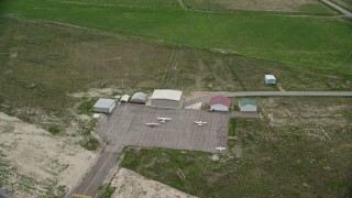 AX130_141 - 5.5K aerial stock footage of orbiting small planes and hangars, Manti-Ephraim Airport, Ephraim, Utah