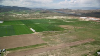 AX130_148 - 5.5K aerial stock footage fly over farmland toward Gunnison Reservoir, Manti, Utah