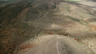 AX130_156E - 5.5K aerial stock footage of flying over dirt roads in dry hills, Sterling, Utah