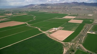 AX130_166 - 5.5K aerial stock footage of flying by farmland and a barn, Aurora, Utah