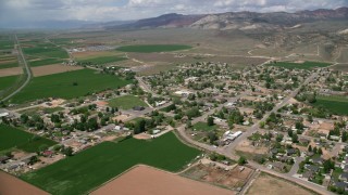 AX130_169 - 5.5K aerial stock footage video of flying by rural town, pan across neighborhoods, roads, Aurora, Utah
