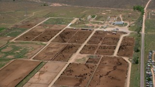 AX130_174 - 5.5K aerial stock footage of flying by large cattle ranch, surrounded by fields, Aurora, Utah