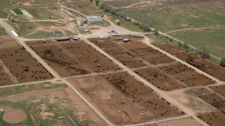 AX130_175 - 5.5K aerial stock footage of orbiting a large cattle ranch, surrounded by fields, Aurora, Utah