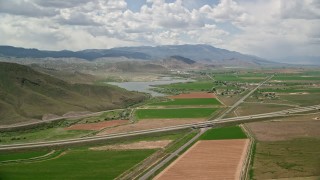AX130_176 - 5.5K aerial stock footage of flying by small town, farmland, Highway 89 and Route 24 crossing, Rocky Ford Reservoir, Sigurd, Utah