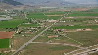 AX130_177E - 5.5K aerial stock footage of flying by rural town, pan to Rocky Ford Reservoir, farmland, Sigurd, Utah