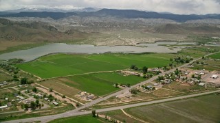 AX130_179 - 5.5K aerial stock footage of passing a rural town, farmland and Rocky Ford Reservoir, Sigurd, Utah