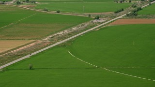 AX130_180 - 5.5K aerial stock footage of following Route 118 through farmland, circular crop fields, Sigurd, Utah