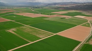 AX130_186E - 5.5K aerial stock footage fly over farmland, pan to Route 118, Richfield, Utah
