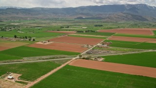 AX130_189 - 5.5K aerial stock footage of flying by farmland, Route 118, Richfield, Utah