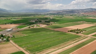 AX130_191 - 5.5K aerial stock footage of flying over farmland near Route 118, approach rural town, Richfield, Utah