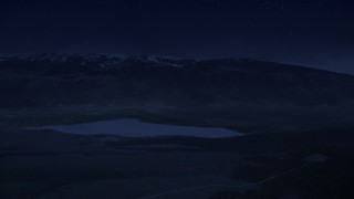 AX130_210_DFN - Aerial stock footage of 4K day for night color corrected aerial footage flyby Koosharem Reservoir, snowy mountains in background, Fishlake National Forest, Utah