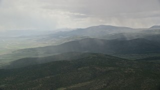 AX130_213 - 5.5K aerial stock footage of rain falling on mountains in Fishlake National Forest, Utah