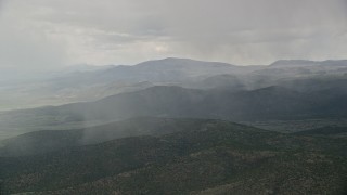 AX130_214 - 5.5K aerial stock footage of flying by rain falling on mountains, trees, Fishlake National Forest, Utah