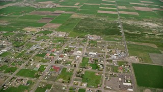 AX130_234E - 5.5K aerial stock footage of circling a small rural town and farmland, Loa, Utah