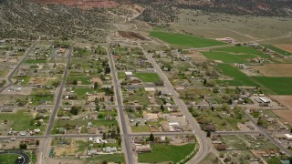 AX130_237E - 5.5K aerial stock footage of orbiting Wayne High School in small rural town, Bicknell, Utah