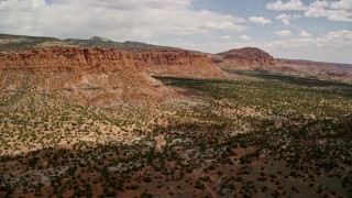 AX130_244E - 5.5K aerial stock footage pan from mesas and approach a butte, Capitol Reef National Park, Utah