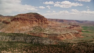 AX130_247E - 5.5K aerial stock footage of orbiting a butte topped with trees, Capitol Reef National Park, Utah