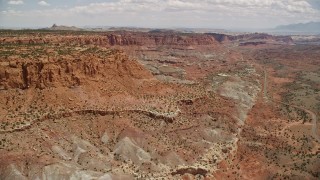 AX130_252E - 5.5K aerial stock footage approach and pan across mesa topped with trees, Capitol Reef National Park, Utah