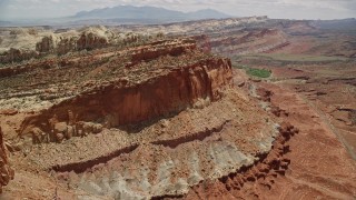 AX130_261E - 5.5K aerial stock footage flyby mesa cliffs, reveal and approach small butte, Waterpocket Fold, Capitol Reef National Park, Utah