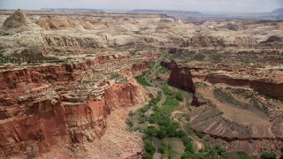 AX130_267 - 5.5K stock footage aerial video flyby Waterpocket Fold rock formations, desert road through canyon, Capitol Reef National Park, Utah