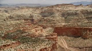 AX130_274E - 5.5K aerial stock footage of bird's eye view of dirt road through a canyon, parked cars, Capitol Reef National Park, Utah