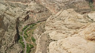 AX130_278 - 5.5K aerial stock footage of orbiting desert road, Waterpocket Fold rock formations, Capitol Reef National Park, Utah