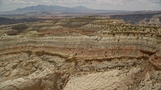 AX130_290E - 5.5K aerial stock footage fly over and approach mesas, Capitol Reef National Park, Utah