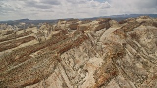 AX130_304E - 5.5K aerial stock footage pan across and flyby canyons in Waterpocket Fold rock formations, Capitol Reef National Park, Utah