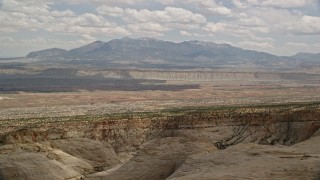 AX130_318 - 5.5K aerial stock footage of flying by distant mesas, mountains, Capitol Reef National Park, Utah