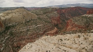 AX130_326E - 5.5K aerial stock footage flying by canyons, mesas, beside Waterpocket Fold, Capitol Reef National Park, Utah