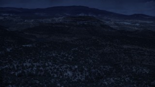 AX130_338_DFN - Aerial stock footage of 4K day for night color corrected aerial footage of approaching a desert peak, over desert vegetation, Capitol Reef National Park, Utah