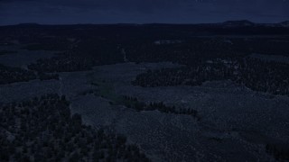AX130_346_DFN - Aerial stock footage of 4K day for night color corrected aerial footage of flying over desert valley, green vegetation, Dixie National Forest, Utah